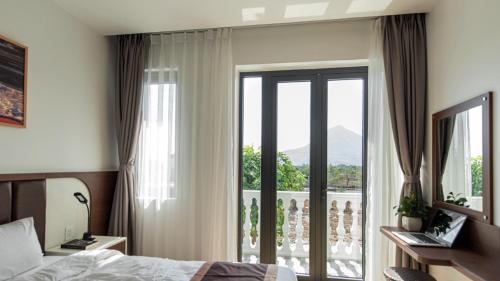 Un dormitorio con una cama y una ventana con vistas. en Heaven Villa Hotel Nha Trang, en Cam Ranh