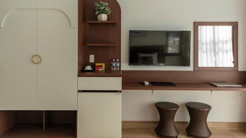 cocina con 2 sillas y escritorio con TV en Heaven Villa Hotel Nha Trang, en Cam Ranh