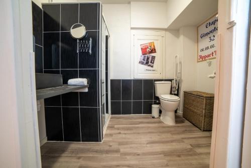 La salle de bains est pourvue de toilettes et d'un lavabo. dans l'établissement etape gimontoise 32 "Chambre tout confort", à Gimont