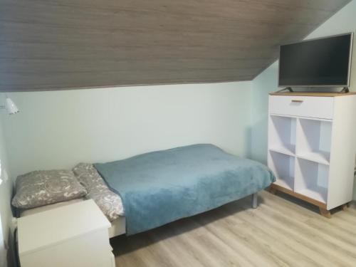 ein kleines Schlafzimmer mit einem Bett und einem TV in der Unterkunft Wakacyjne Domki in Ustronie Morskie
