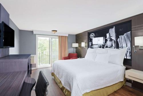 una habitación de hotel con una cama y un televisor en Super 8 by Wyndham Sturbridge, en Sturbridge