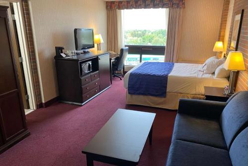 a hotel room with a bed and a television at Ramada by Wyndham Lethbridge in Lethbridge