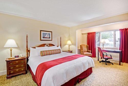 a hotel room with a large bed and a desk at Ramada by Wyndham Seekonk Providence Area in Seekonk