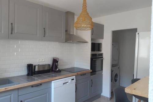 une cuisine avec des armoires blanches et un comptoir dans l'établissement Maison Aigues-Mortes 8 couchages, à Aigues-Mortes