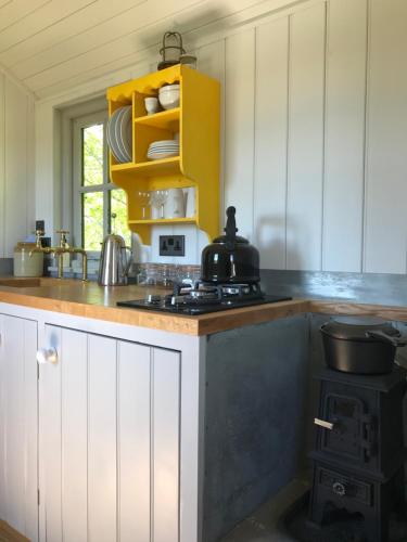 a kitchen with white cabinets and a stove top oven at Barnham Court Farm in Barnham