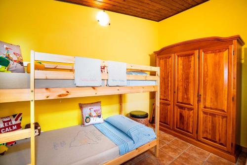 sypialnia z 2 łóżkami piętrowymi i żółtą ścianą w obiekcie Villa Alecla - Sea Villa near Taormina w mieście SantʼAlessio Siculo