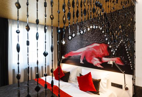 a bed with a headboard with a red woman on it at Bohem Art Hotel in Budapest
