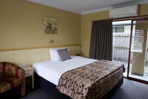 a hotel room with a bed and a window at Blenheim Spa Motor Lodge in Blenheim