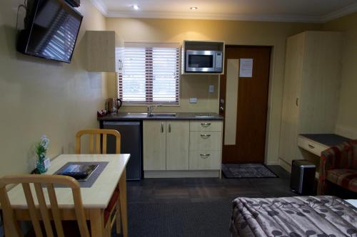 a small kitchen with a sink and a table at Blenheim Spa Motor Lodge in Blenheim