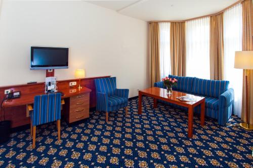 a hotel room with two chairs and a desk and a television at Hotel & Apartments Zarenhof Berlin Prenzlauer Berg in Berlin