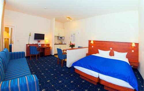 a hotel room with a bed and two chairs at Hotel & Apartments Zarenhof Berlin Prenzlauer Berg in Berlin