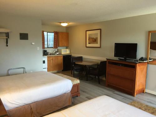 a hotel room with a bed and a small kitchen at VIP Motel in Parksville