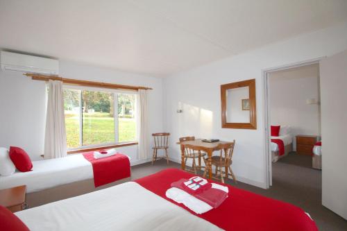 Habitación de hotel con 2 camas, mesa y ventana en Port Arthur Motor Inn, en Port Arthur