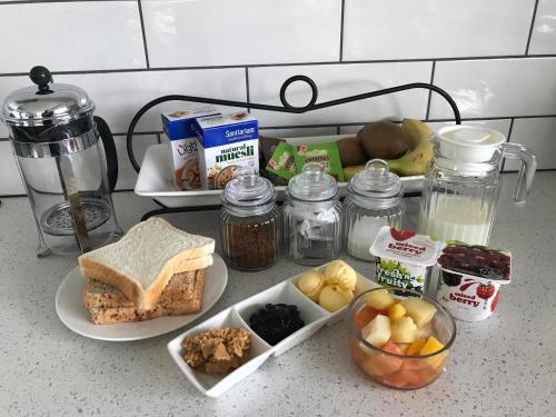 a counter top with a sandwich and other food items at Maungatautari Outlook Cambridge in Cambridge