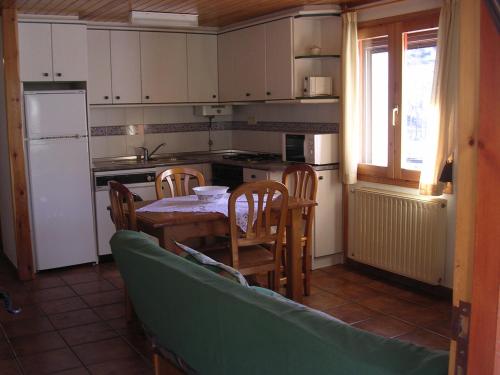 eine Küche mit einem Tisch und Stühlen sowie einem Kühlschrank in der Unterkunft Casa Torres in San Juan de Plan