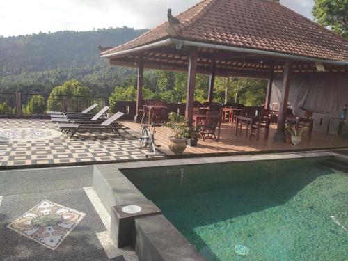 une terrasse avec un pavillon et une piscine dans l'établissement Adila Warung and Homestay, à Munduk