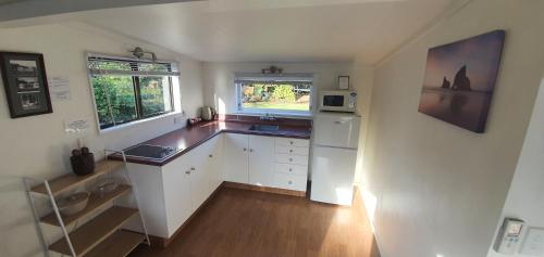 a kitchen with white cabinets and a white refrigerator at Accent On Taupo Motor Lodge in Taupo
