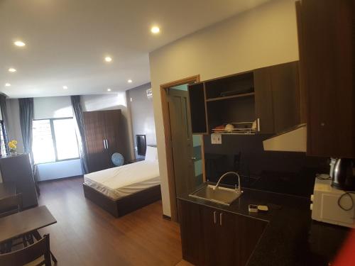 a room with a bed and a kitchen with a sink at xh apartment in Danang
