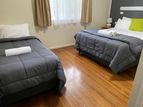 a bed room with two beds and a desk at BIG4 NRMA Atherton Tablelands Holiday Park in Atherton