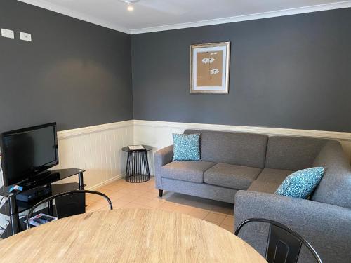 a living room with a couch and a table at NRMA Atherton Tablelands Holiday Park in Atherton