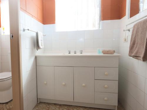 a bathroom with a white sink and a toilet at Lake Edge Apartments in Burrill Lake