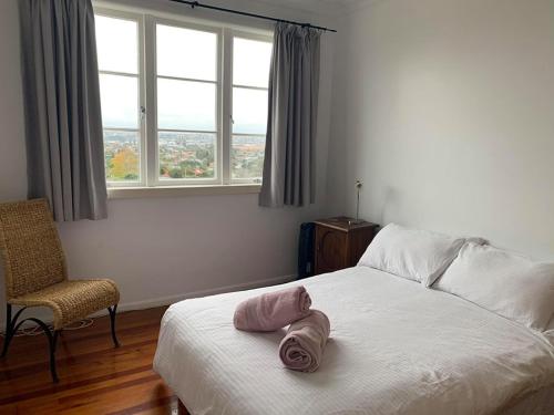 Un dormitorio con una cama con una toalla rosa. en Kiwi Heritage Homestay, en Auckland