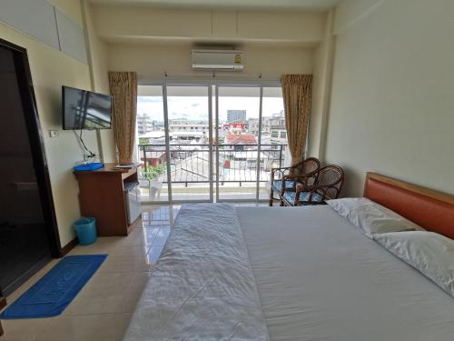 a bedroom with a bed and a tv and a balcony at Subhamitra Hotel Hua Hin-SHA Certified in Hua Hin