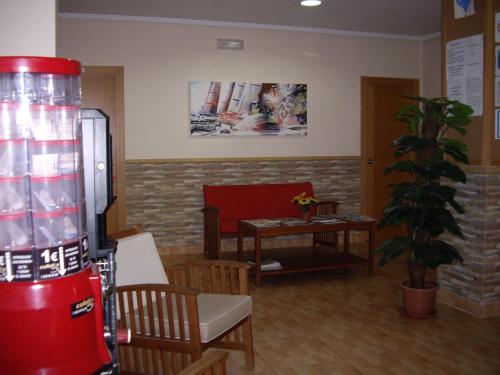 a waiting room with a drink machine and a table at Hostal Abastos in Valencia