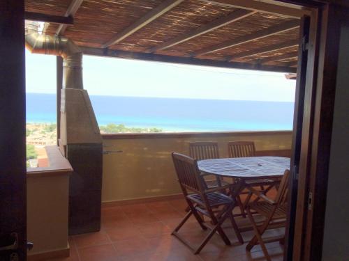 una mesa y sillas en una cocina con vistas al océano en Villetta Best Vacation Ever, Costa Rei, en Costa Rei