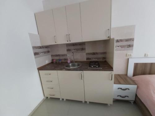 a small kitchen with white cabinets and a sink at Goga Guest House in Kvariati