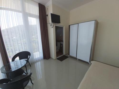 a room with a table and chairs and a large window at Goga Guest House in Kvariati