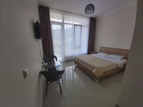 a bedroom with a bed and a window and a chair at Goga Guest House in Kvariati