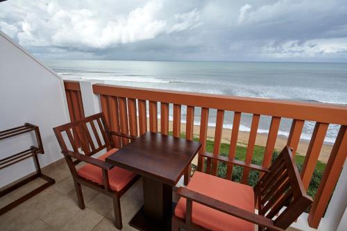 a table and chairs on a balcony with the ocean at Turyaa Kalutara in Kalutara