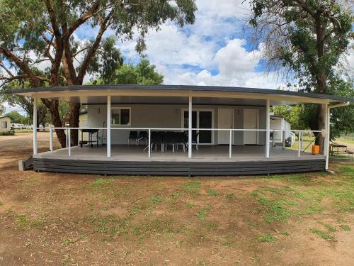 a house with a porch with a table at Gulgong Tourist Park in Gulgong