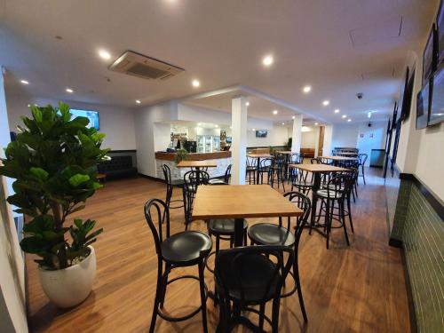 a restaurant with tables and chairs in a room at Empire Hotel Goulburn in Goulburn