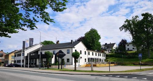 a white building on the corner of a street at Hotell Åsen in Anderstorp