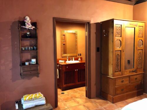 uma casa de banho com um lavatório e um espelho em Gunnadoo Holiday Hut with Ocean Views and Jacuzzi em Miallo