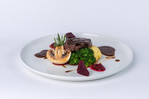 a plate of food with meat and vegetables on a white plate at Dølen Hotel in Evje