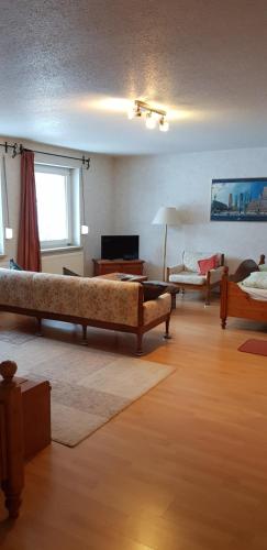 ein Wohnzimmer mit 2 Betten und einem Sofa in der Unterkunft Ferienwohnung Römerstein in Bad Sachsa