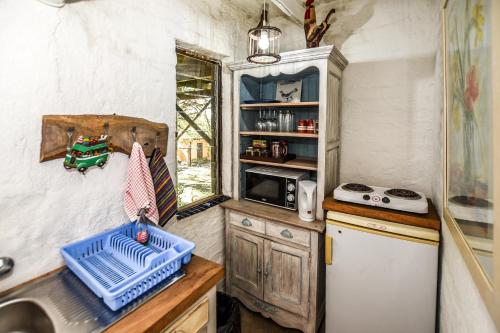 a small kitchen with a sink and a refrigerator at Eloff Guest House and Gallery in White River
