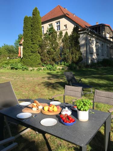 una mesa con frutas y verduras en un patio en Gutshaus Alt-Jargenow en Alt Jargenow