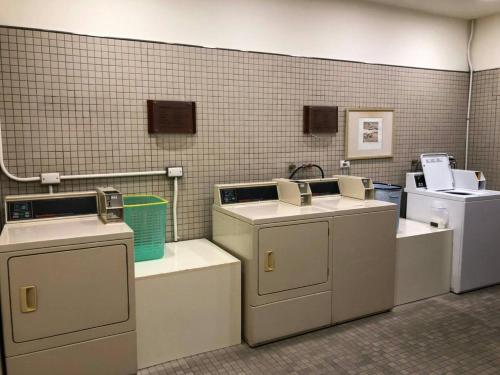 a laundry room with three washers and a sink at Hotel Royal Hsinchu in Hsinchu City