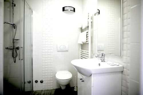 a bathroom with a toilet and a sink and a shower at Hotel Josipdol in Josipdol