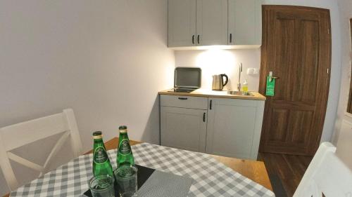 a kitchen with a table with four bottles on it at Uroczysko starych sztolni in Szklarska Poręba