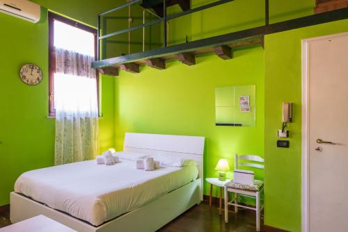 zieloną sypialnię z łóżkiem i oknem w obiekcie Gardappartamenti Carducci City Centre w mieście Desenzano del Garda