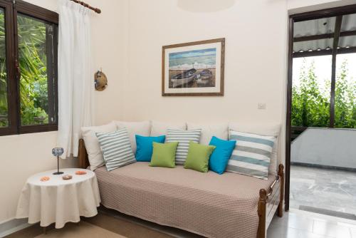 a room with a bed with blue and green pillows at ILIOCHARI sea view apartments Oropos - Kalamos in Kalamos