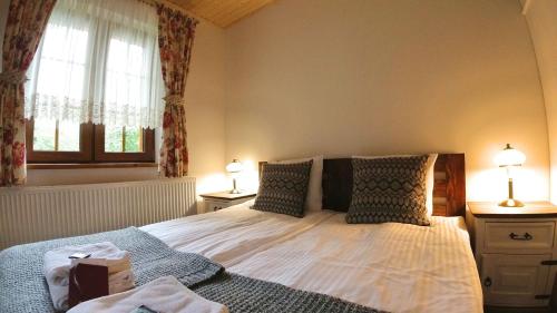 a bedroom with a bed with two lamps and a window at Uroczysko starych sztolni in Szklarska Poręba