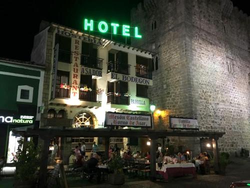a hotel with people sitting outside of it at night at Hostería El Bodegón De Gredos in Arenas de San Pedro