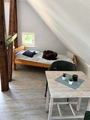 Zimmer mit einem Bett und einem Tisch mit einem sidx sidx in der Unterkunft Gutshaus Alt-Jargenow in Alt Jargenow