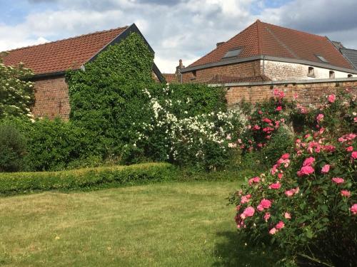 a garden with pink flowers and a brick building at Villa Theresa à 25 min de PAIRI DAIZA in Soignies